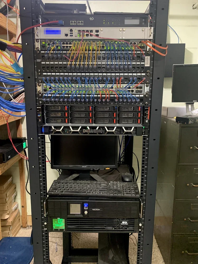 Full-height network rack with firewall, switches, patch panels, a server and battery backup