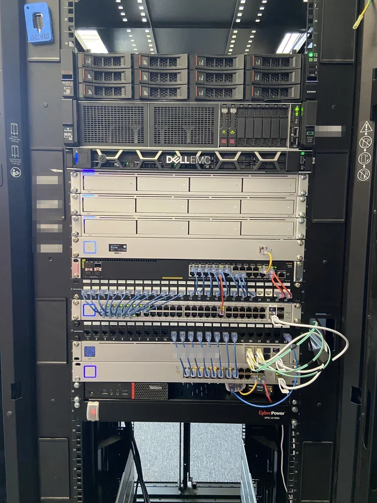 Black server cabinet with servers, storage units, switches, patch panels and a battery backup